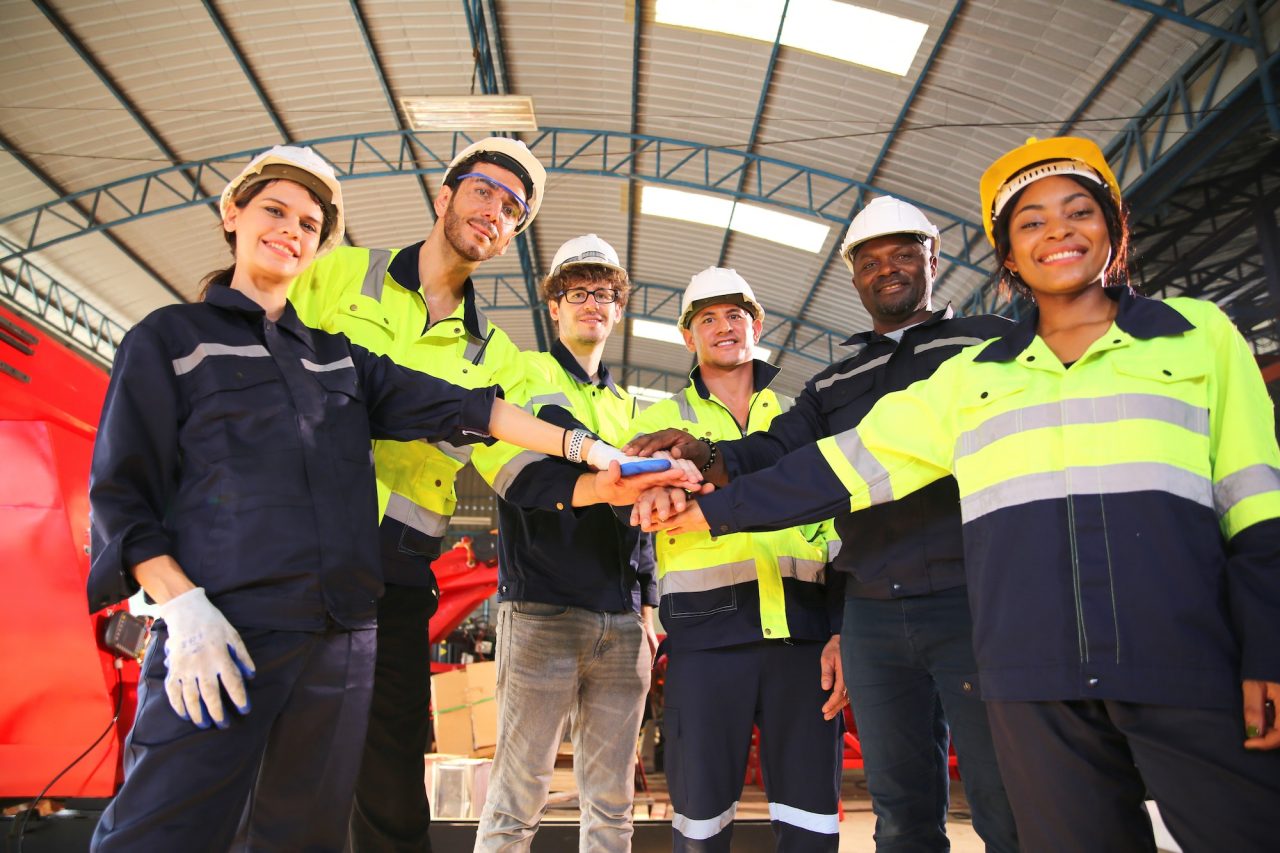 group-of-young-multiracial-industry-workers-stacking-hands-together